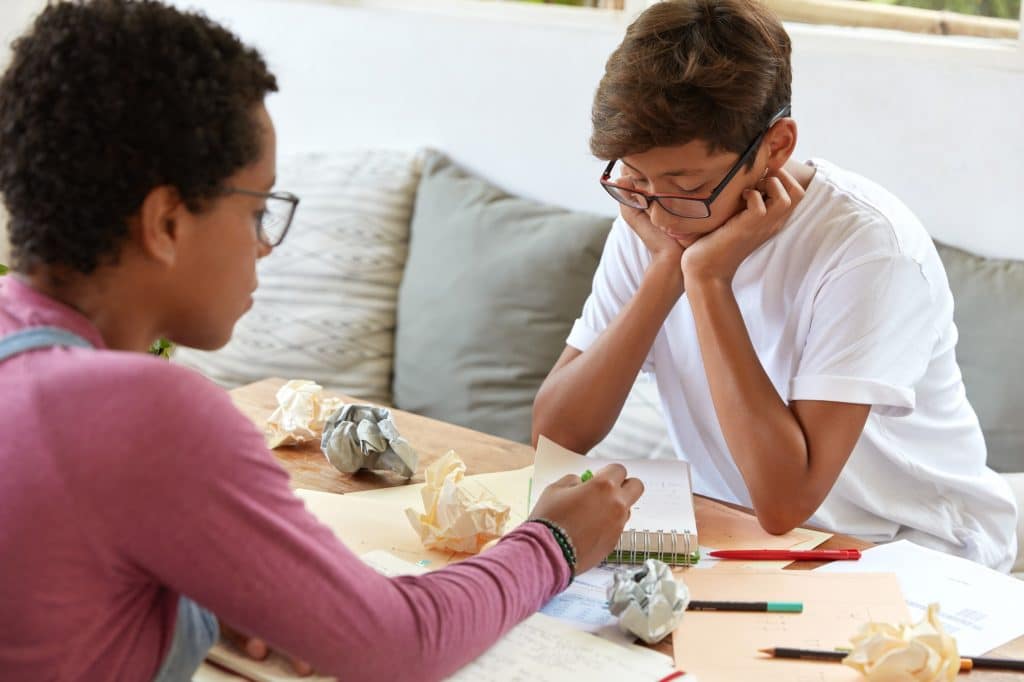 Menino e mãe estudando juntos.