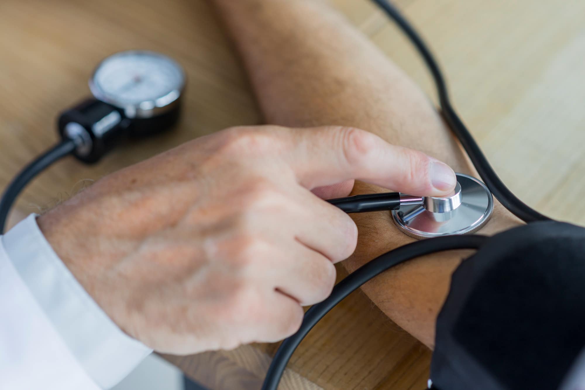 Médico aferindo pressão de paciente.