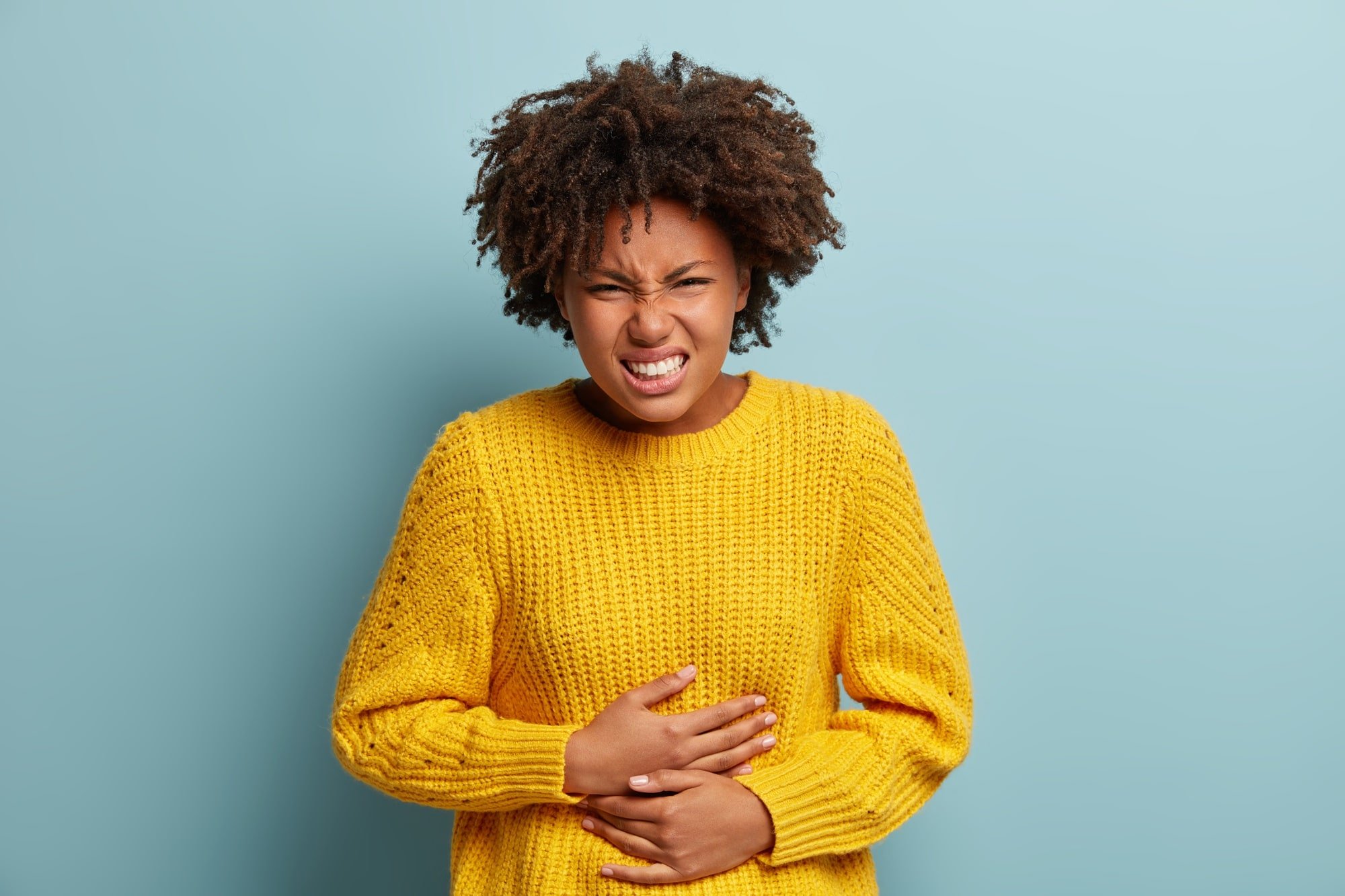 Mulher com dor de barriga. Imagem de Freepik.